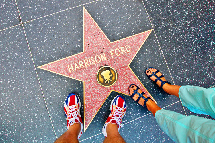 Visitors standing on a Hollywood Walk of Fame star during a Hollywood Bus Tour experience