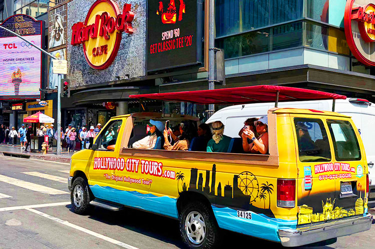 Hollywood Tour bus parked near entertainment landmarks on Hollywood Boulevard